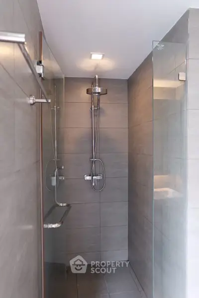 Modern bathroom with sleek glass shower and gray tile walls