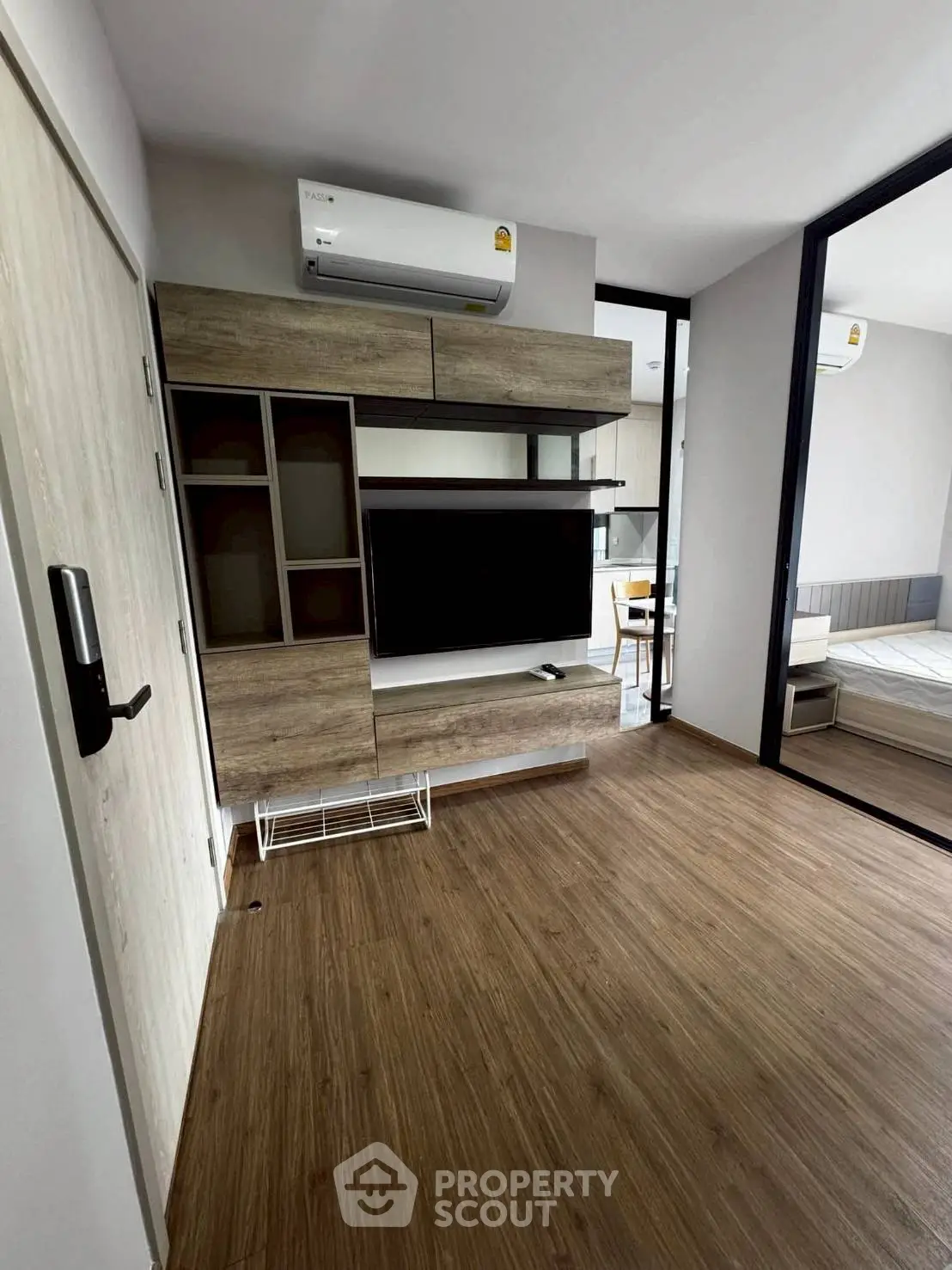 Modern living room with wooden flooring and sleek TV unit