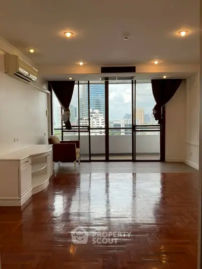 Spacious living room with city view and large balcony access