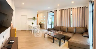 Spacious modern living room with large sectional sofa and dining area, featuring stylish decor and ample natural light.