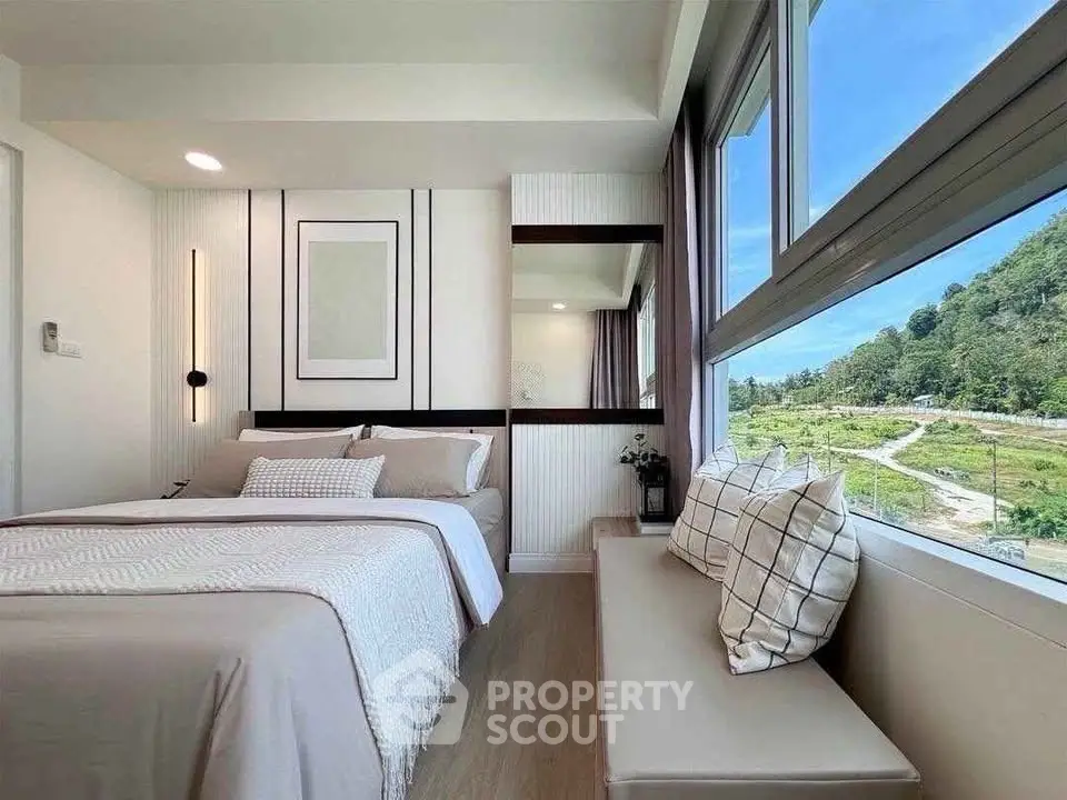 Modern bedroom with large window offering scenic views and stylish decor.