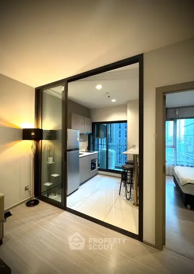 Modern apartment with open kitchen and city view, featuring sleek design and natural light.