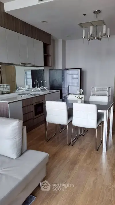 Modern kitchen with sleek cabinetry, open layout, and dining area in a stylish apartment.