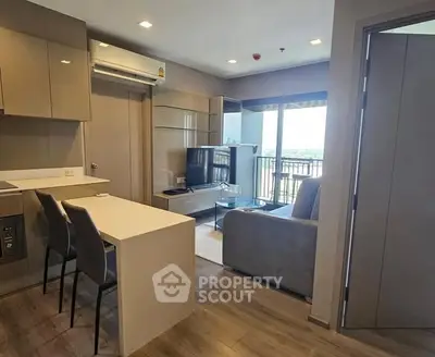 Modern open-layout living room with kitchen and balcony view in a stylish apartment.
