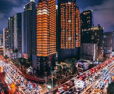 Stunning cityscape view of illuminated skyscrapers and bustling traffic at night.