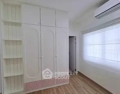 Modern bedroom with built-in wardrobe and air conditioning unit