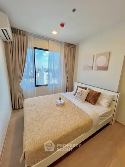 Modern bedroom with city view, cozy decor, and natural light