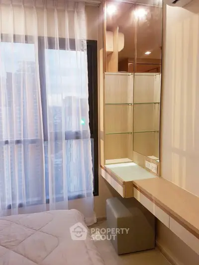 Modern bedroom with city view, featuring sleek built-in furniture and large windows for natural light.