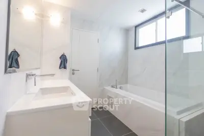 Modern bathroom with sleek design, featuring a bathtub and large window for natural light.