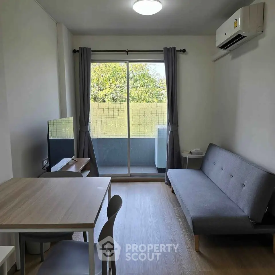Modern living room with balcony view, featuring sleek furniture and natural light.