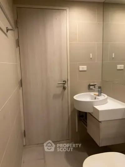 Modern bathroom with sleek design and compact sink in a contemporary apartment.