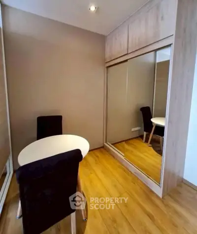 Cozy study room with wooden flooring and mirrored closet doors