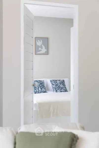 Cozy bedroom with stylish decor and soft lighting, featuring a comfortable bed with decorative pillows.