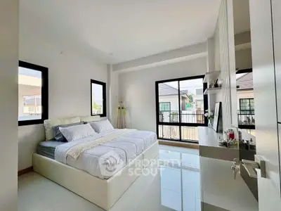 Spacious modern bedroom with large windows and elegant decor in a bright home.