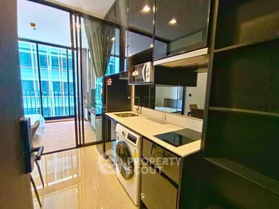 Modern kitchen with sleek black cabinets and built-in appliances in a stylish apartment.