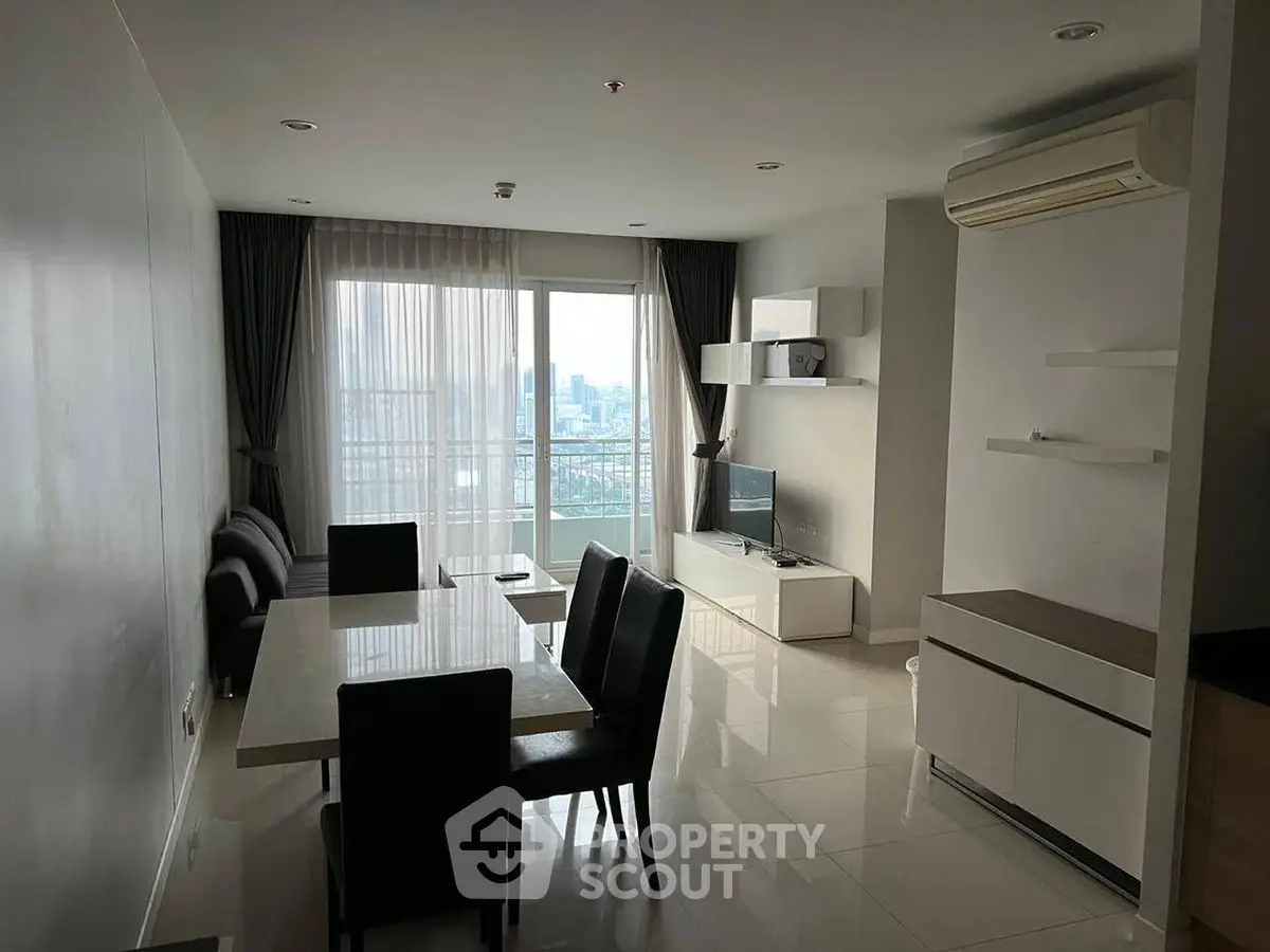 Modern living room with dining area and city view, featuring sleek furniture and natural light.