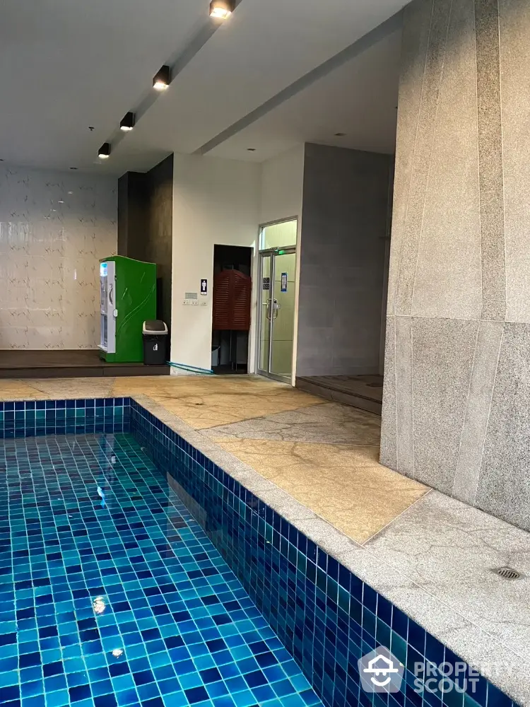 Modern indoor pool area with sleek design and tiled flooring