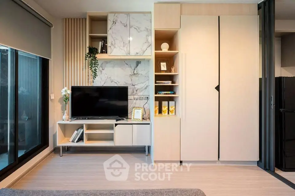Modern living room with stylish storage and large window, perfect for urban living.