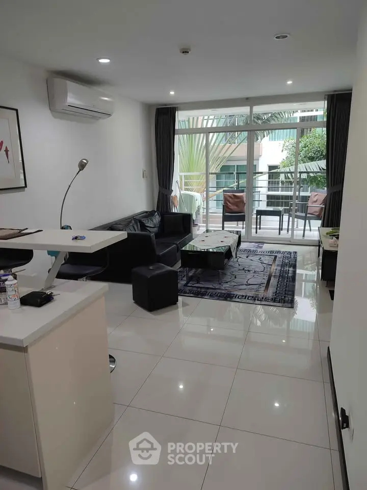 Spacious modern living room with balcony access and sleek furnishings