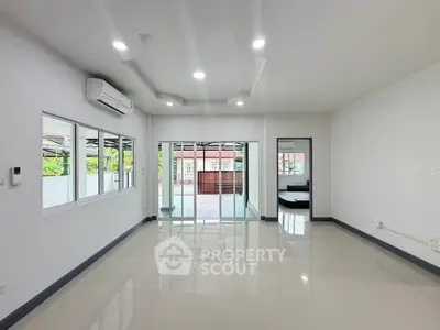 Spacious modern living room with large windows and sleek tile flooring