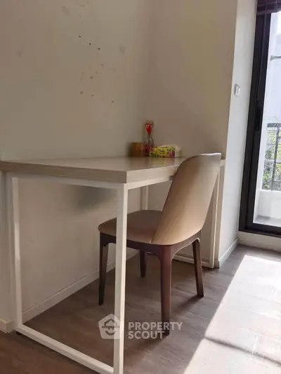 Cozy study nook with modern desk and chair by a sunlit window, perfect for productivity.