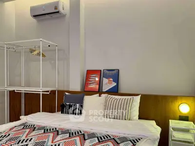 Cozy bedroom with modern decor and air conditioning, perfect for relaxation.