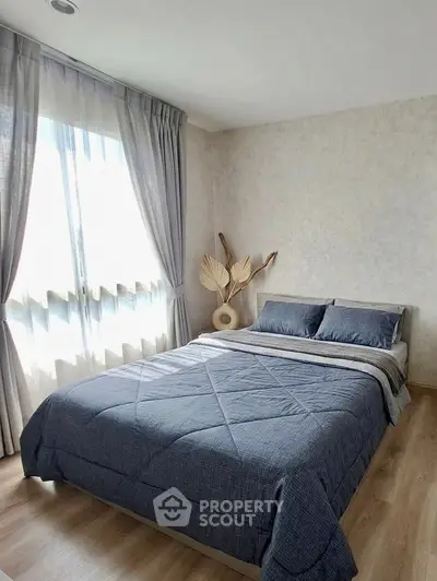 Cozy bedroom with stylish decor and natural light, featuring a comfortable bed and elegant curtains.