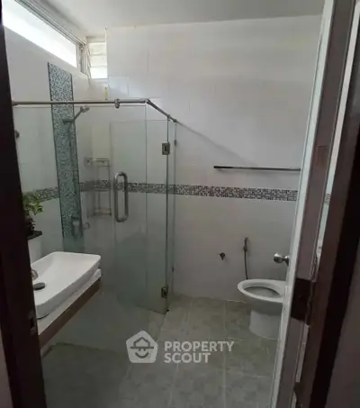 Compact bathroom with glass shower enclosure and modern fixtures
