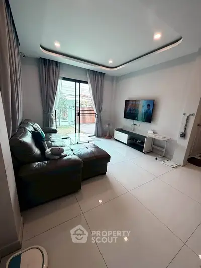 Modern living room with sleek design, large windows, and stylish furniture for a cozy ambiance.