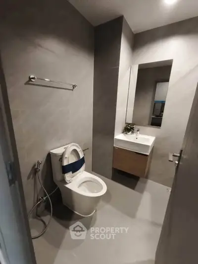 Modern bathroom with sleek design, featuring a wall-mounted toilet and stylish vanity.