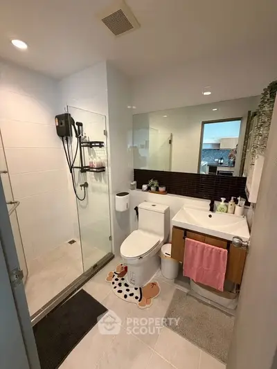 Modern bathroom with glass shower and stylish vanity in a contemporary home.