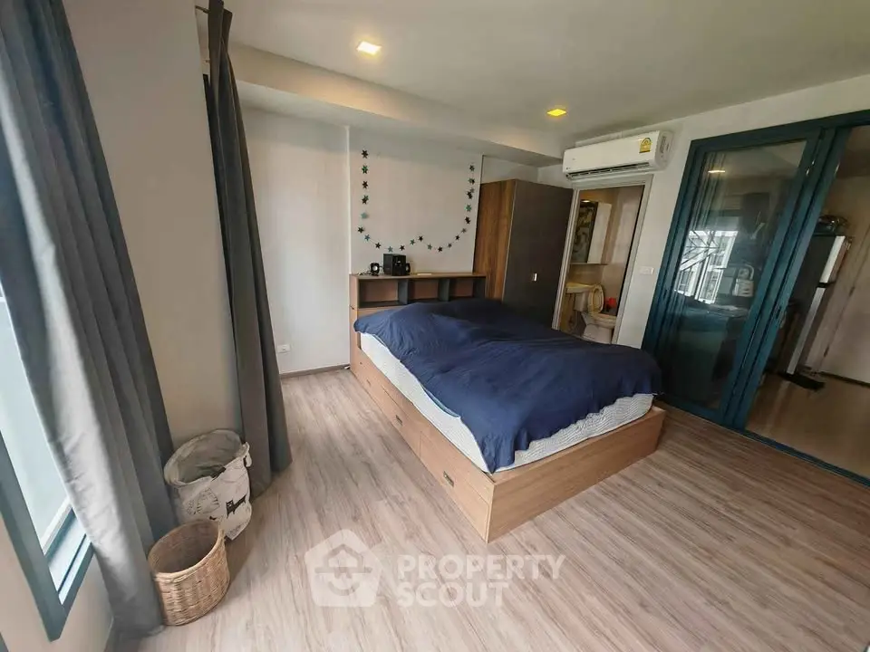 Modern bedroom with wooden flooring and stylish decor in a cozy apartment.