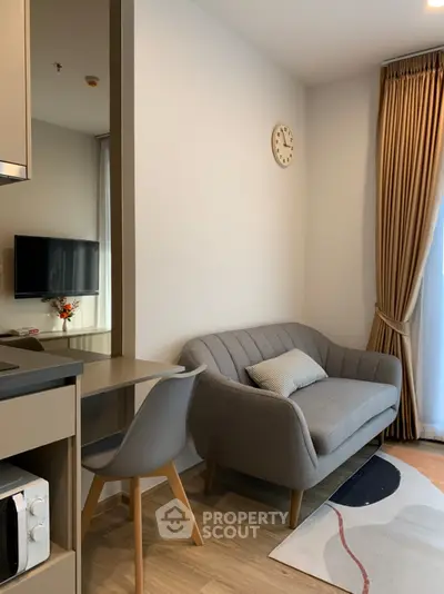 Cozy modern living room with stylish sofa and wall clock, perfect for urban living.