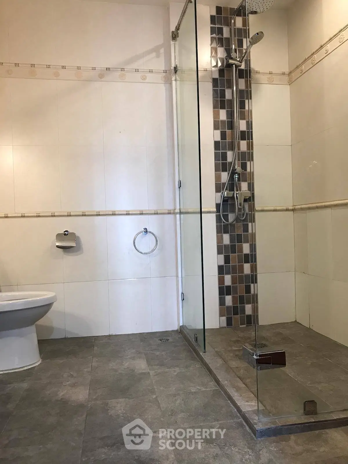 Spacious modern bathroom with glass shower and tiled floor