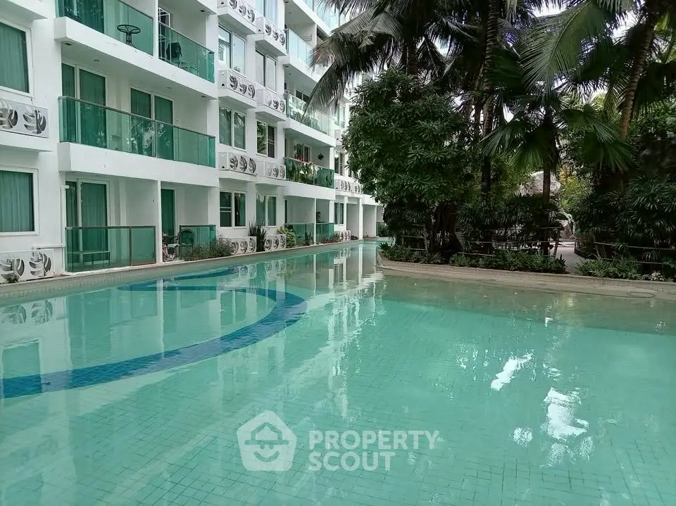 Luxurious apartment complex with a stunning outdoor pool surrounded by lush greenery.