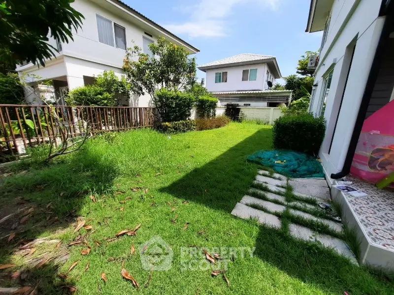 Charming garden view in suburban residential area with lush greenery and modern houses.