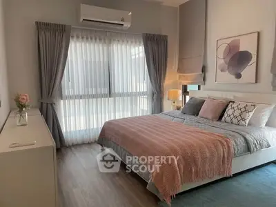 Cozy bedroom with modern decor, featuring a large window, stylish curtains, and elegant bedding.