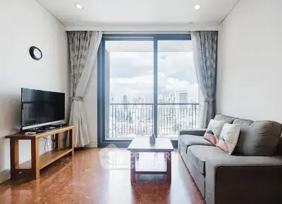 Bright living room with city view, modern furniture, and large windows.