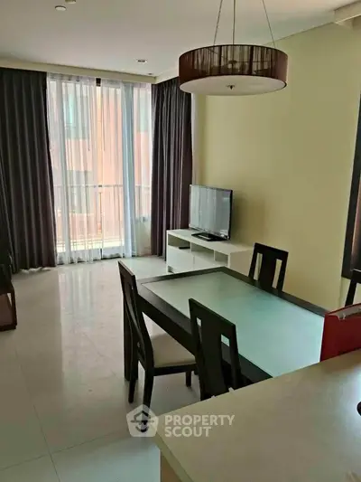Modern living room with dining area and large window in a stylish apartment.