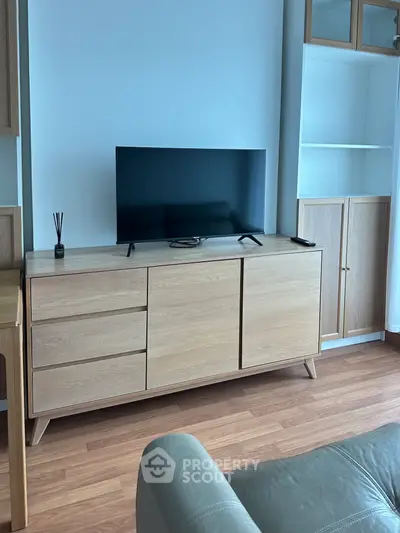Modern living room with sleek wooden TV console and flat-screen TV, perfect for stylish urban living.