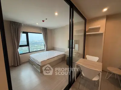 Modern bedroom with city view and study area in high-rise apartment