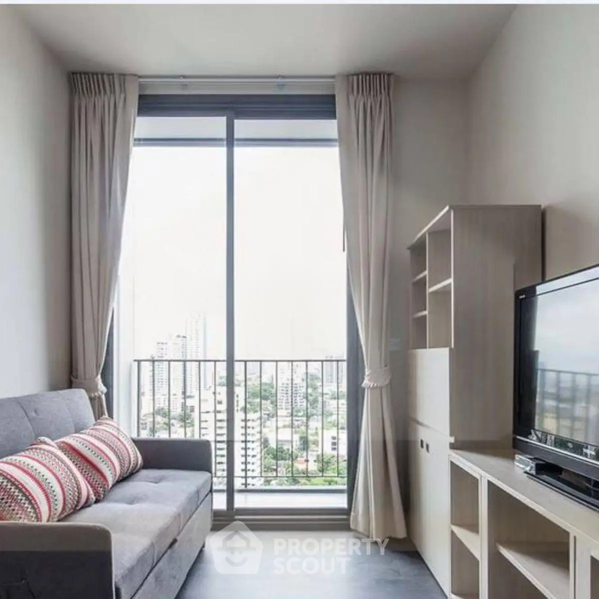 Modern living room with city view, featuring a cozy sofa and entertainment unit.