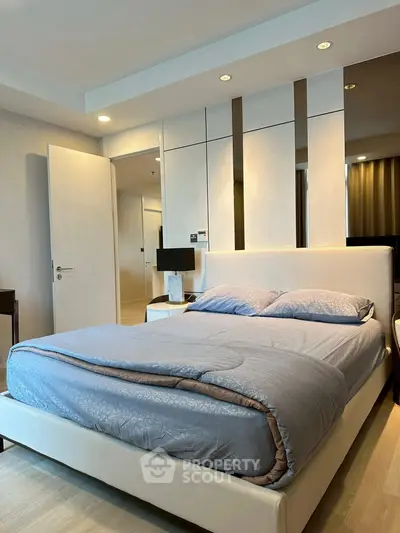 Modern bedroom with stylish decor and cozy bedding in a contemporary apartment.