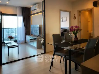 Modern apartment interior with glass dining table and spacious living area.
