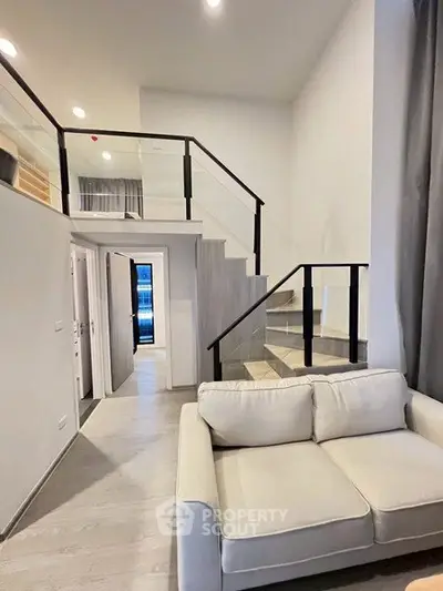 Modern duplex living room with stylish staircase and cozy sofa