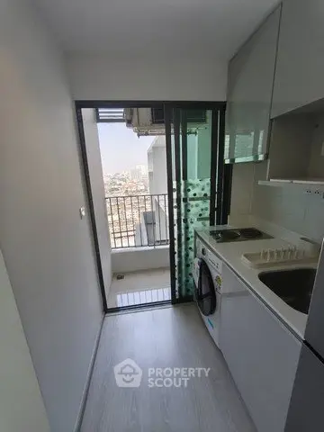 Compact kitchen with balcony view in modern apartment