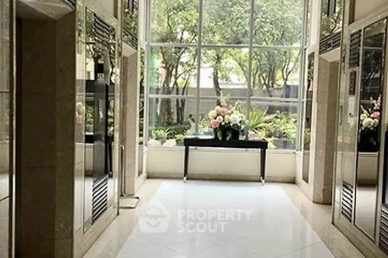 Elegant building entrance with large windows and floral decor