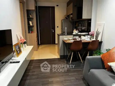 Modern open-layout living room with stylish kitchen and cozy dining area, perfect for urban living.