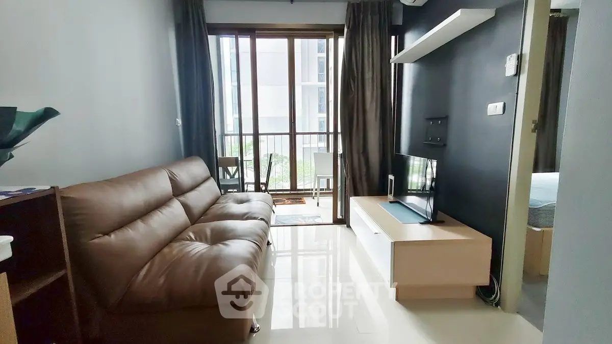 Modern living room with sleek furniture and balcony view in a stylish apartment.