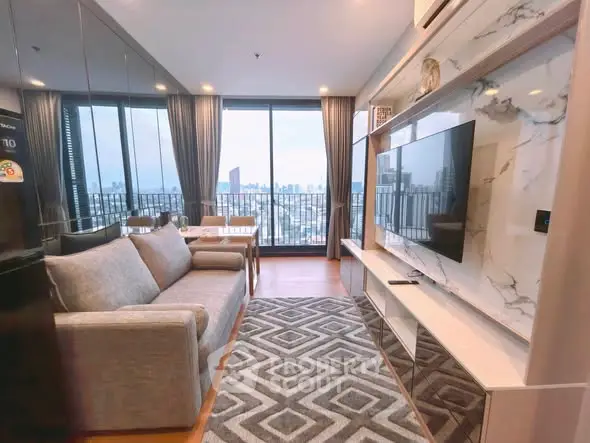 Modern living room with city view, stylish decor, and large windows in a high-rise apartment.